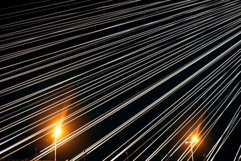 Large cables stretched on a suspension bridge at night Stock Photos