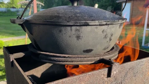 Large camp pot over fire. Pot for cooking over fire. Fire made in grill. Stock Footage 200842832