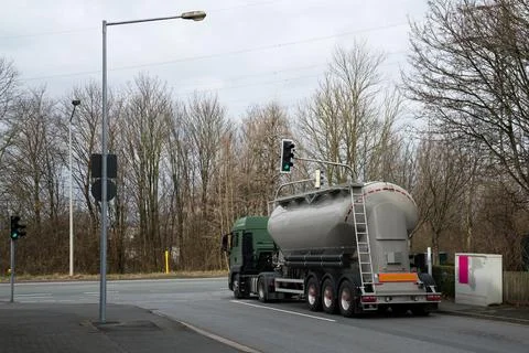A large car with a tank at an empty intersection with a traffic light. Stock Photos