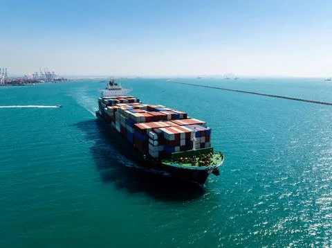 Large Cargo Container Ship Navigating Turquoise Ocean Waters High Angle Shot 스톡 사진