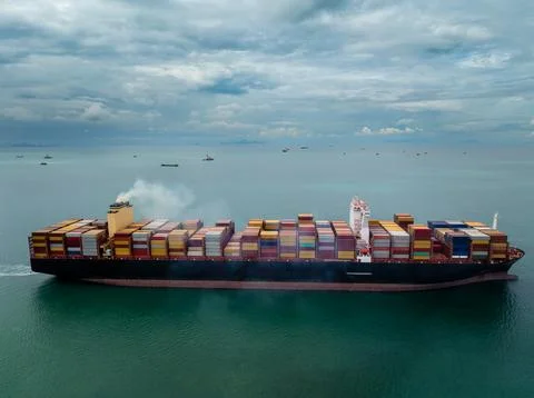 Large Cargo Container Ship Traversing Calm Open Ocean Under Cloudy Skies Wi.. Stockfoto's