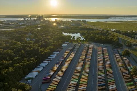 Large cargo container yard with many freight containers and big factory Stock Photos
