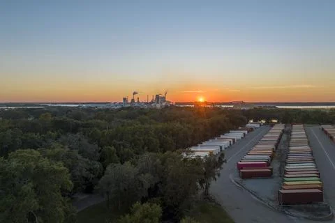 Large cargo container yard with many freight containers and big factory Stock Photos