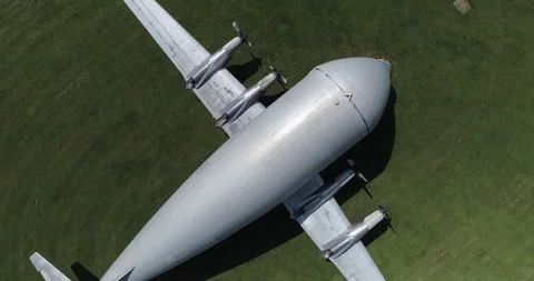 Large cargo plane retired on grass next to runway birds eye view drone aerial 4k Stock Footage 124647286