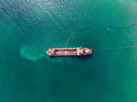 A large cargo ship is anchored in deep blue water. It is positioned to load a Fotos de archivo