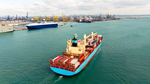 Large Cargo Ship Carrying Containers Navigating Through Industrial Port Wid.. Foto stock
