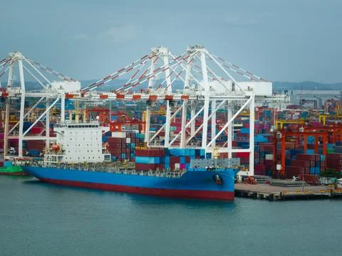 Large Cargo Ship Docking At Busy Container Port With Massive Loading Cranes.. 库存照片