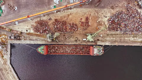 Large cargo ship docks at industrial port to unload scrap metal during the 스톡 동영상 340883193