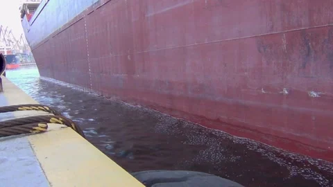 A large cargo ship is moored to the pier in the port to await loading in bulk ca Stock Footage 137256170