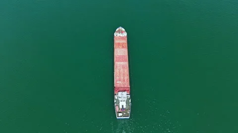 Large cargo ship moves through blue water with many containers stacked on deck Stock Footage 337891612