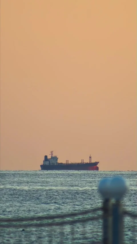 Large cargo ship navigates calm waters toward horizon under expansive sky Stock Footage 330232913