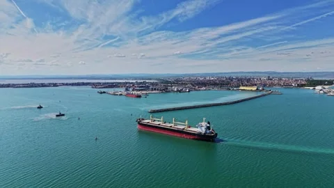 Large cargo ship navigates calm water near busy port city Stock-Footage 339018950