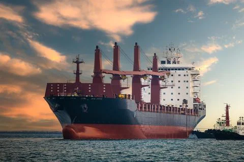 Large Cargo Ship Navigating Open Sea At Sunset Wide Shot Photos