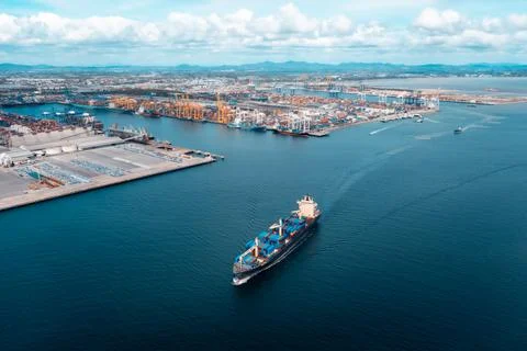 Large Cargo Ship Navigating Through Busy Industrial Harbor Of Laem Chabang .. Stock Photos