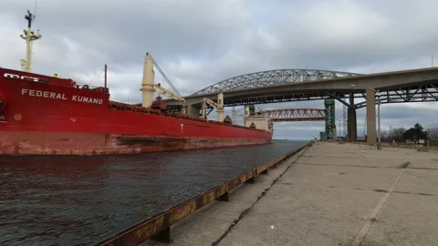 Large cargo ship passing through canal under bridges. Video stock 144958780