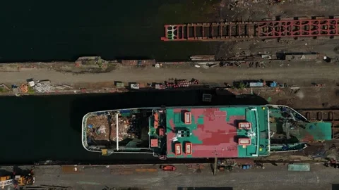 Large cargo ship with red and green sections docks in a canal. Vídeos de archivo 335301116