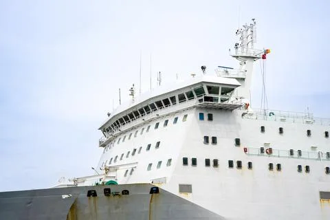 Large cargo ship sails in open water with clear sky in the background Stock Photos