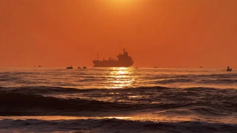Large Cargo Ship Silhouette at Sunrise in the horizon with sea Waves in Stock Footage 342582979