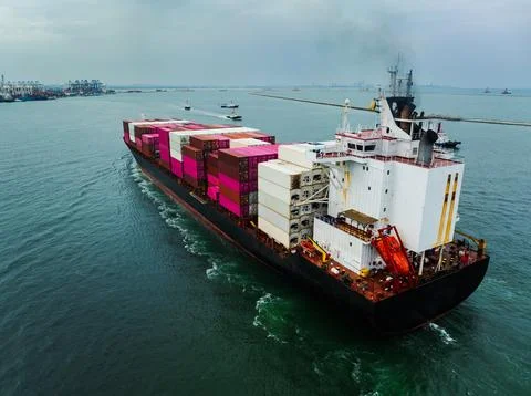Large Cargo Ship Transporting Shipping Containers Through Coastal Waters Ne.. Stock Photos