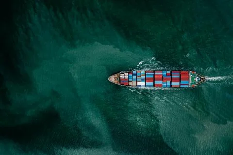 Large Cargo Ship Transporting Shipping Containers Across Turquoise Ocean Wa.. Photos