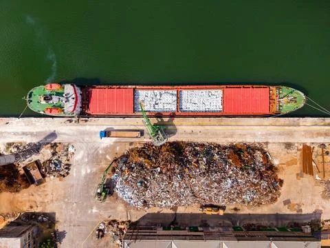 Large cargo ship unloads materials at a busy industrial port with container.. Stock Photos