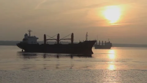 Large cargo ships at anchor sunset evening calm sea. Large ship coast orange sun Stock Footage 137255984