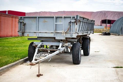A large cargo trailer parked on the side of a quiet road, its massive frame.. 스톡 사진