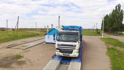 Large cargo trucks weighing cargo on truck scales in rural area Stock Footage 148324693
