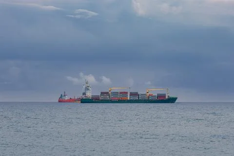 Large cargo vessel loaded with multi-colored containers Stock Photos