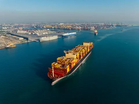 Large Cargo Vessel Transporting Containers Through Deep Blue Sea Aerial View Stock Photos