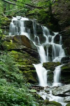 Large cascading waterfall in a mountain forest Stock Photos