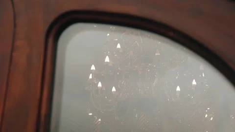 A large chandelier hanging on the ceiling is reflected in the glass. Stock Footage 237623139