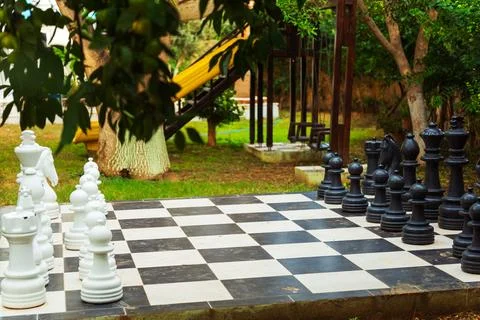 A large chess board featuring oversized giant chess pieces placed on it Stock Photos