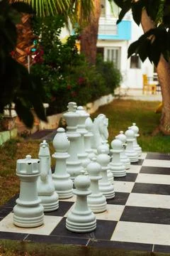 A large chess board featuring oversized giant chess pieces placed on it Stock Photos