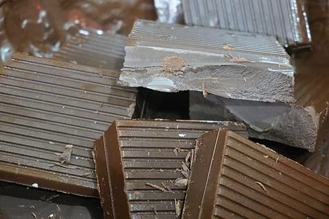 Large chocolate chunks in a container being melted Stock-Fotos