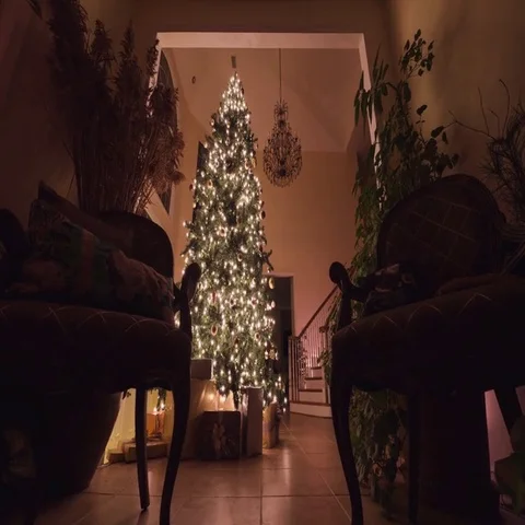 Large Christmas tree with glowing lights, ornaments, and presents. Stock Footage 69497320