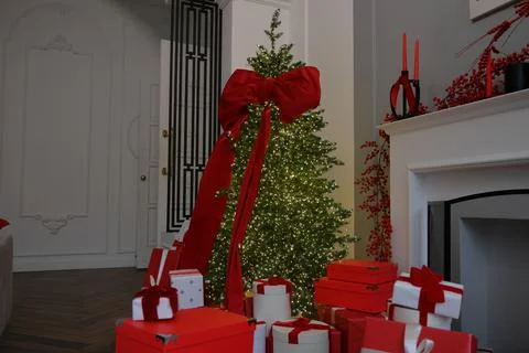 Large Christmas tree with red bow and toys. New Year's decor, gift box on Stock Photos