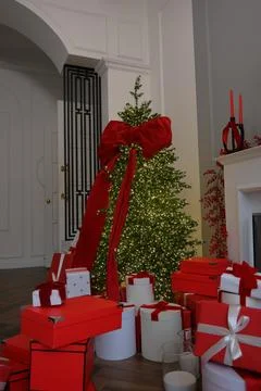 Large Christmas tree with red bow and toys. New Years decor, gift box on Stock Photos