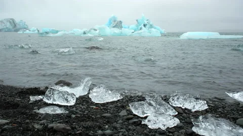 Large chunk of ice and pure blue iceberg in foggy glacier lagoon, Icelandic Stock Footage 221941487