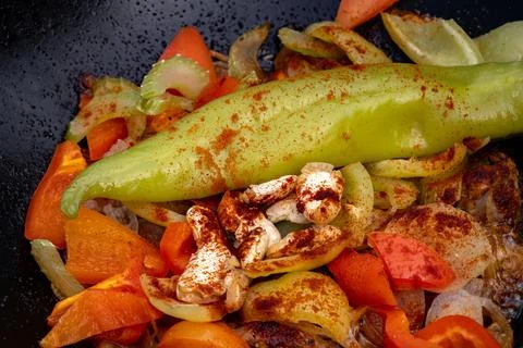 Large chunks of asian vegetables and meat fried in oil with bubbles in a bl.. Stock Photos