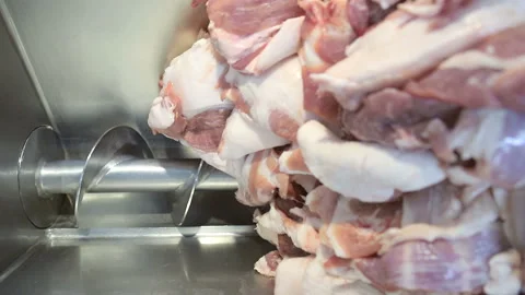 Large chunks of meat that fall into an industrial meat grinder. Deboning of meat Stock Footage 114351334