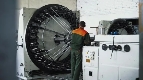Large circular braiding machine operated by technician amid factory Vídeo Stock 320013545