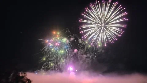 Large circular firework burst combined with vibrant multicolored fireworks Stock Photos