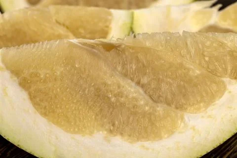 Large citrus fruit cut into several pieces with juicy sweet flesh, large citrus Stock Photos