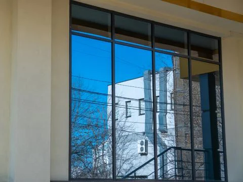 A large, clean window that reflects the opposite house. Stock Photos