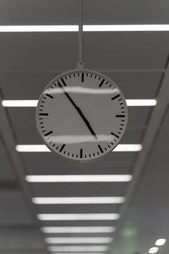 Large clock hanging and a row of white lights behind Stock Photos