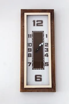 A large clock mounted on a white wall Stock Photos