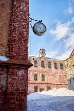 A large clock on the red brick wall of a production building against the back Stock Photos