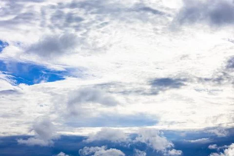 Large cloud covers sun in dark blue rainy sky Stock Photos