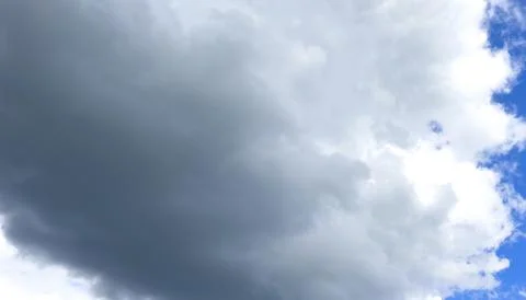 Large cloud mass floats across blue sky with soft light. Billowing formation 스톡 사진